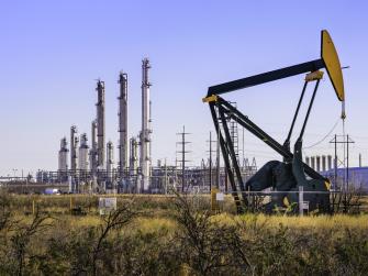 A pumpjack (oil derrick) and oil refinery in Seminole, West Texas. 