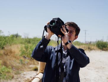 A researcher uses a handheld imaging device outdoors.