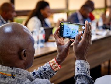 Workshop participant holding up a smartphone to photograph a presentation.